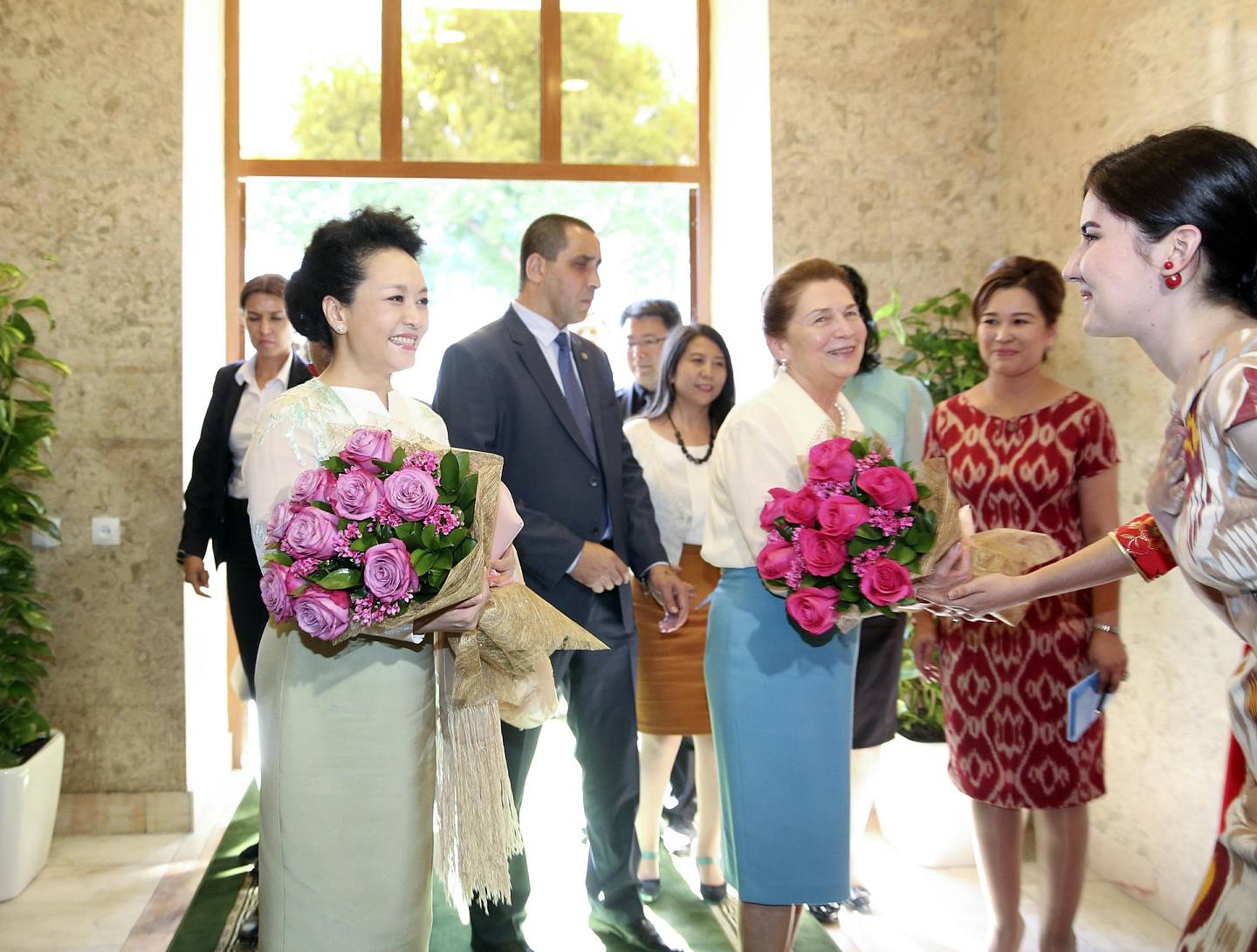 塔什干孔子學院學生向彭麗媛和烏茲別克斯坦總統卡里莫夫夫人卡里莫娃獻花。（新華社）