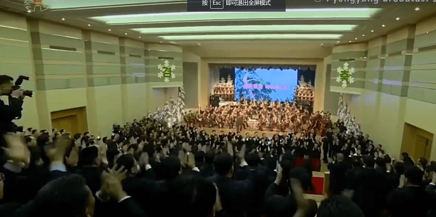 演出开始前，朝鲜民众起立鼓掌欢迎金正恩。（朝鲜中央电视台视频截图）