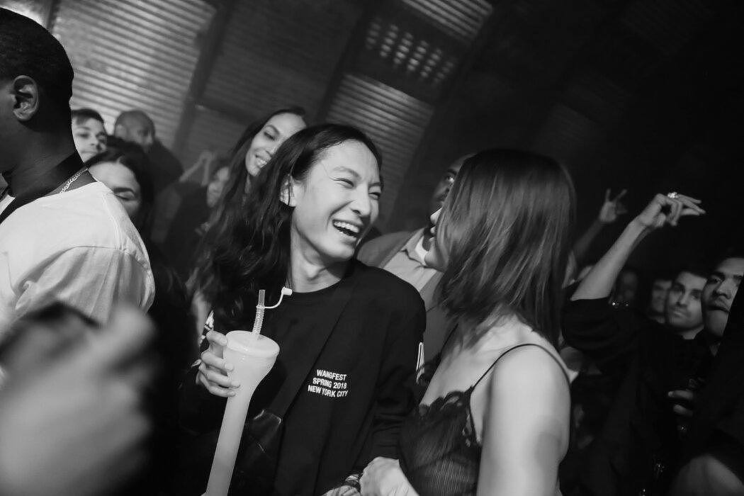 2017年，王大仁和贝拉·哈迪德在布鲁克林一个仓库举办的秀后派对的音乐会上。