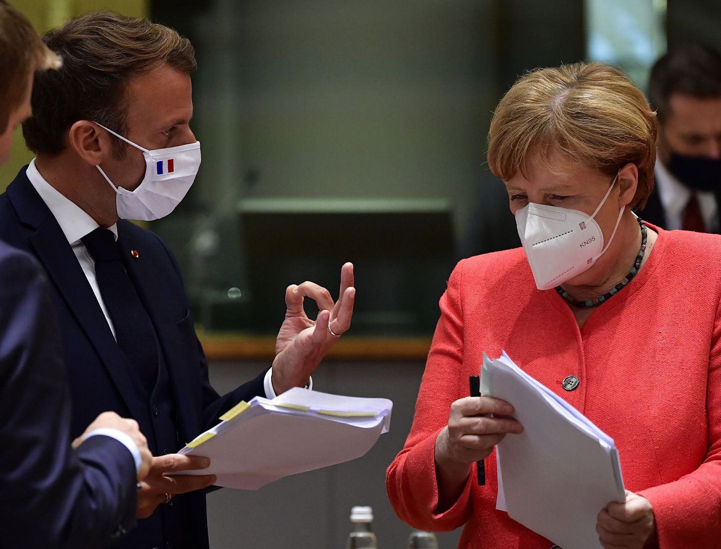 德国总理默克尔（Angela Merkel，右）与法国总统马克龙（Emmanuel Macron，左）两人都开始转变了对中俄疫苗的态度。图为两人2020年7月在欧盟峰会在正式会议开始前私下交换意见。（AP）