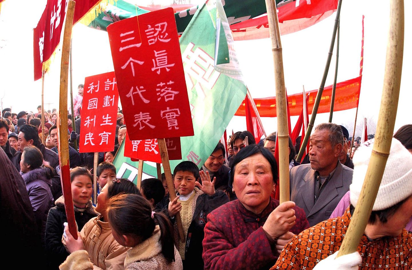 2003年，河南乡村民间集会上流动的标语牌：认真落实三个代表，计划生育利国利民。（视觉中国）
