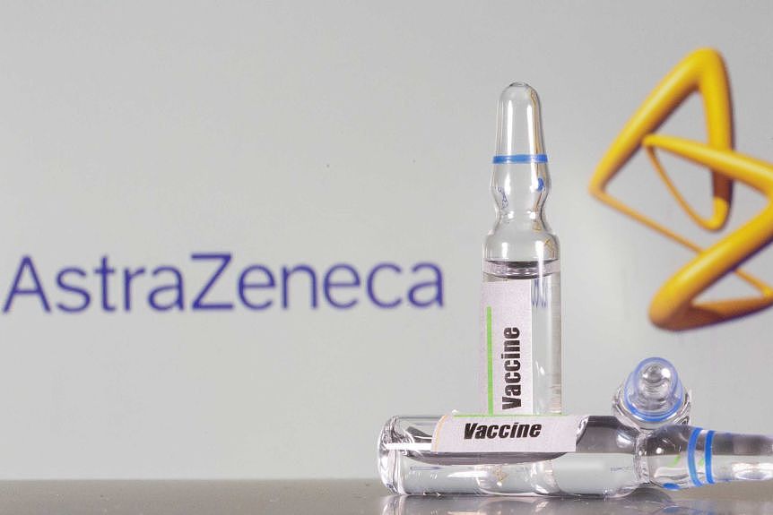 A AstraZeneca logo sits behind vials of generic vaccine. 