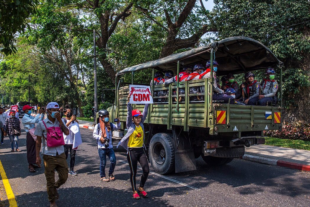 仰光一辆军用卡车旁边的抗议者。