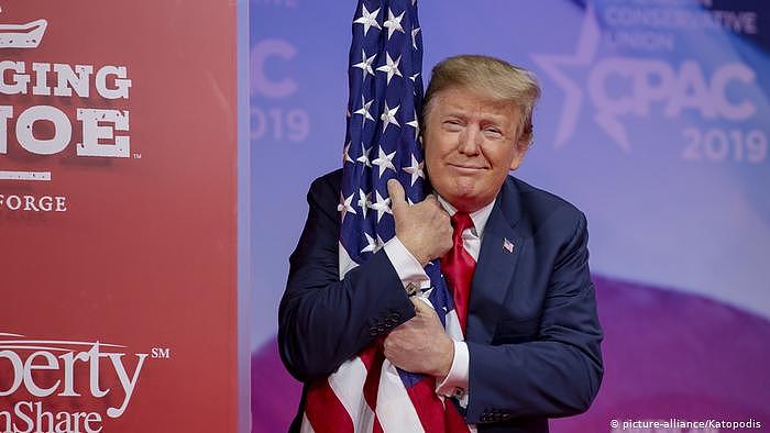 Präsident Trump umarmt die US Flagge