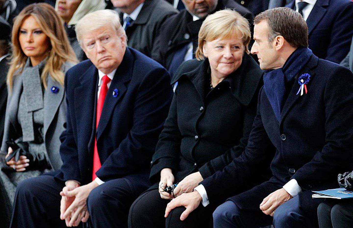 2018年11月11日，在巴黎举行的一战结束百年的纪念活动中，德国总理默克尔与法国总统马克龙交谈。远道而来的时任美国总统特朗普（Donald Trump）则显出某种无法插话的局促。（Getty Images）