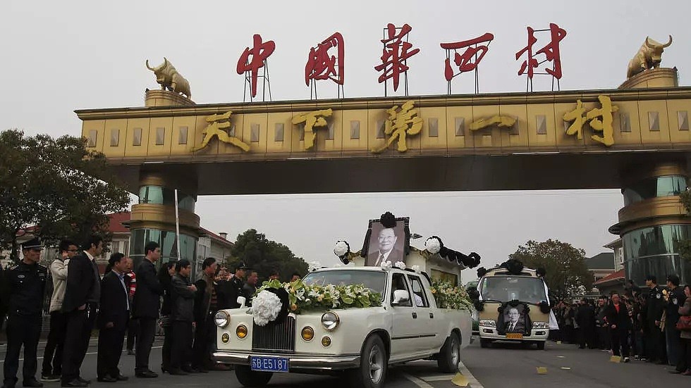 2013年3月22日，华西村书记吴仁宝逝世，图为载着棺材的豪华轿车驶过华西村大门，华西村位于中国东部江苏省江阴市。