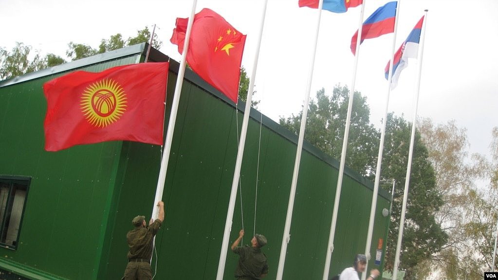 中亚国家经常与中国和俄罗斯共同参加一些活动。 2014年在莫斯科郊外的军事比赛活动中，俄罗斯军人升中国和吉尔吉斯国旗。 （美国之音白桦拍摄）