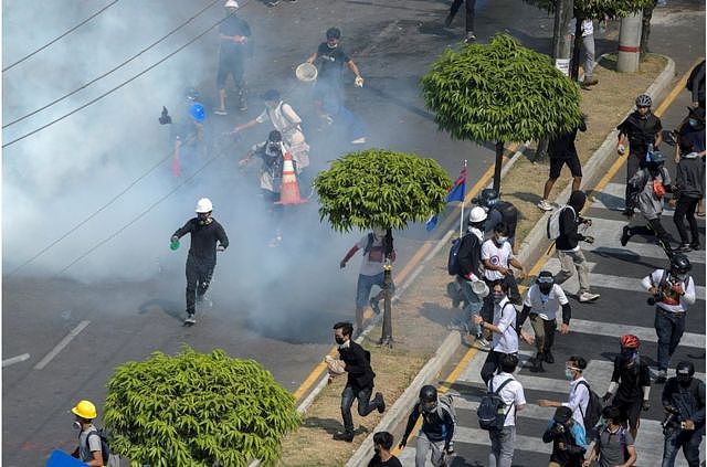 仰光民众针对军事政变的抗议活动中，示威者逃离警方释放的催泪瓦斯（2021年2月28日）。