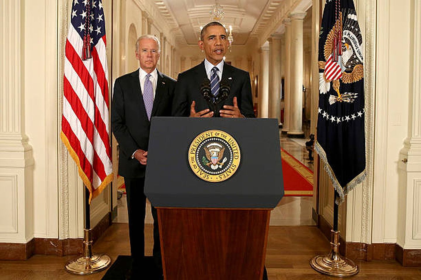 2015年7月14日，时任美国总统奥巴马（Barack Obama)与副总统拜登(Joe Biden)在白宫东厅举行新闻发布会，回答有关《伊朗核协议》的记者提问。这项具有里程碑意义的协议将限制伊朗的核项目，以换取解除美国对伊朗的制裁。这项协议经过近两年的外交努力，也得到了伊朗总统鲁哈尼（Hassan Rouhani）的赞扬。（Getty）
