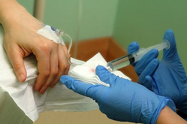 一位病人在接受化疗，手上插了针头。