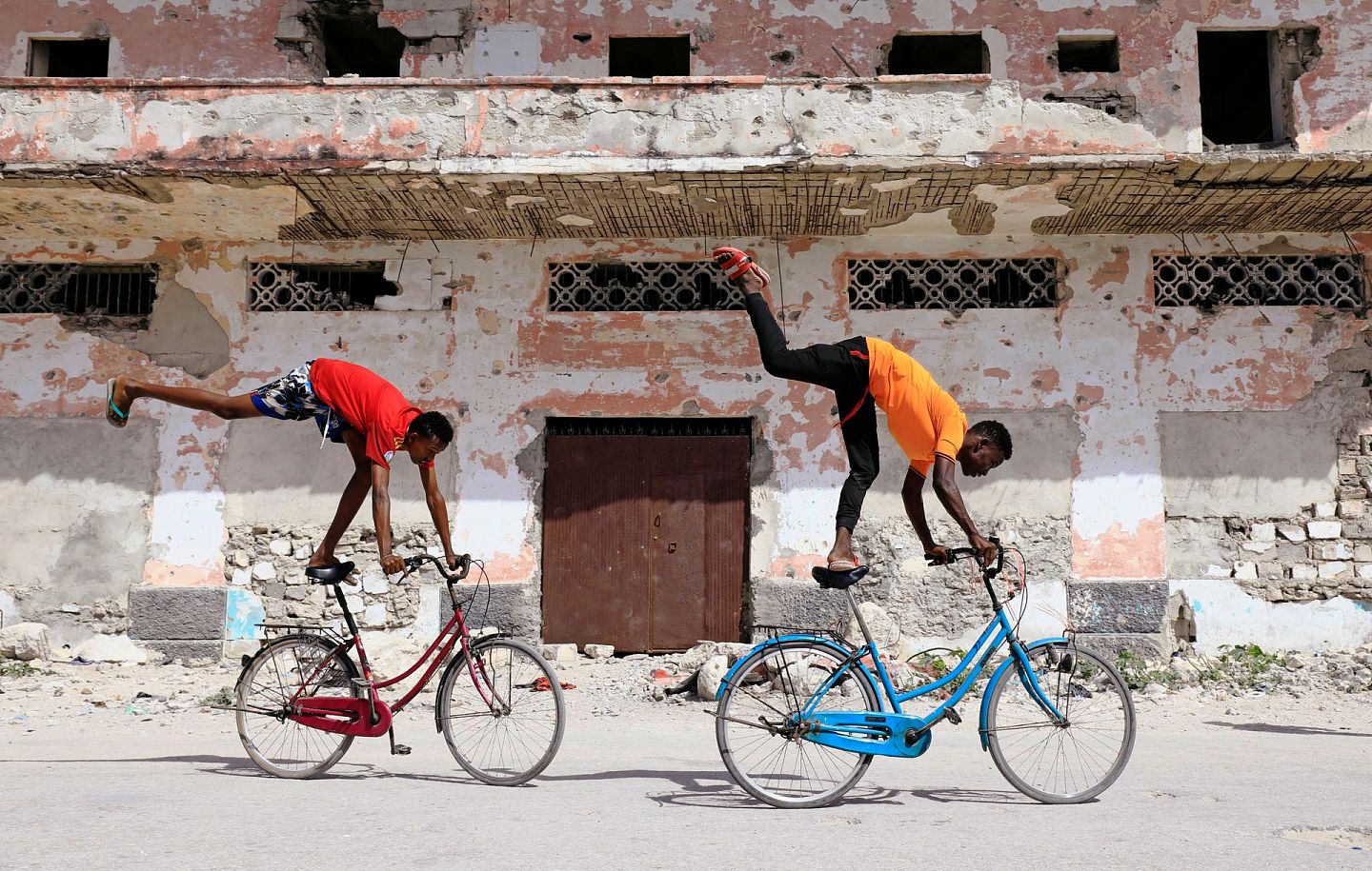 索马里的战乱虽然暂时告一段落，但当地民不聊生的局面仍然很突出，图中的少年为换取餐费不得不卖艺求生。（路透社）