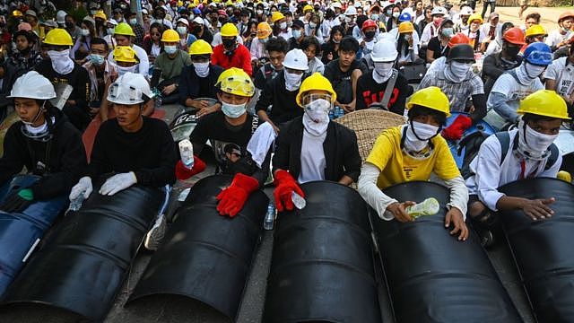 Protesters wear protective equipment and hold homemade shields as they prepare to face off against security forces during a demonstration against the military coup in Yangon on March 5, 2021.