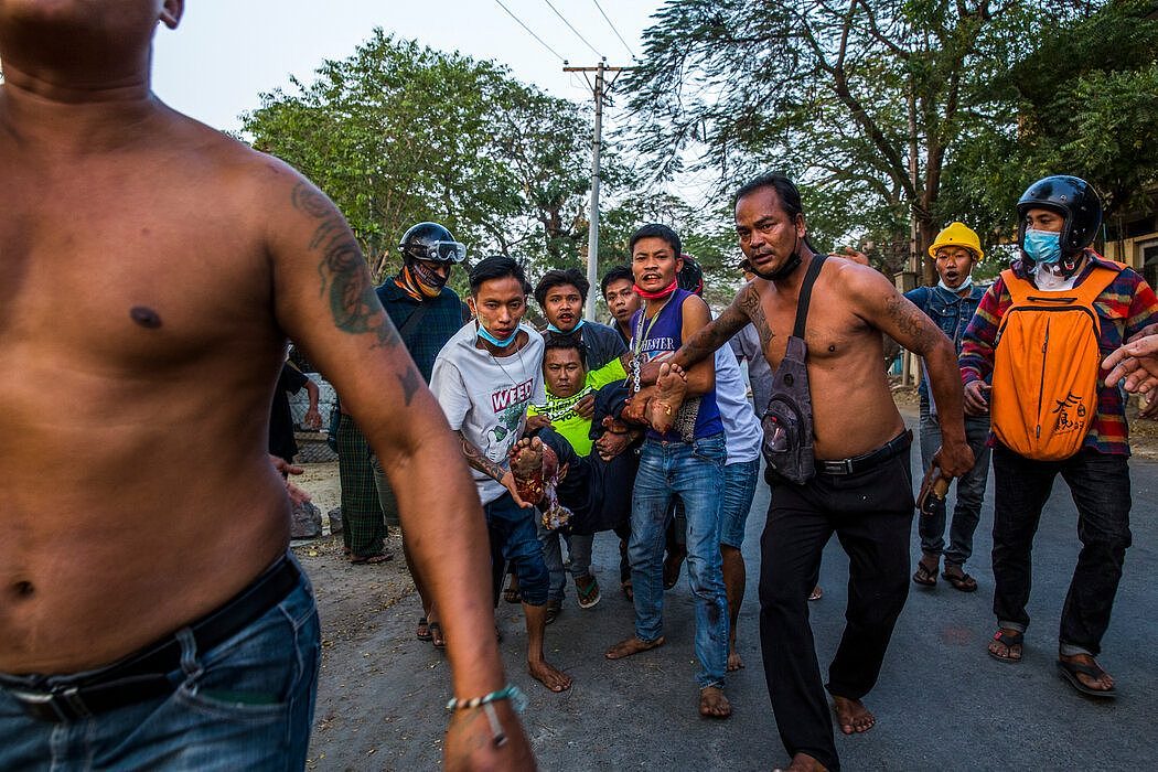 2月28日，在缅甸的曼德勒，人们帮助一名在抗议活动中遭安全部队枪击的男子。
