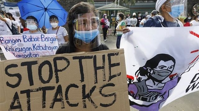 A protester holds a sign during a rally marking International Women's Day in Quezon City, Metro Manila, Philippines, 8 March 2021