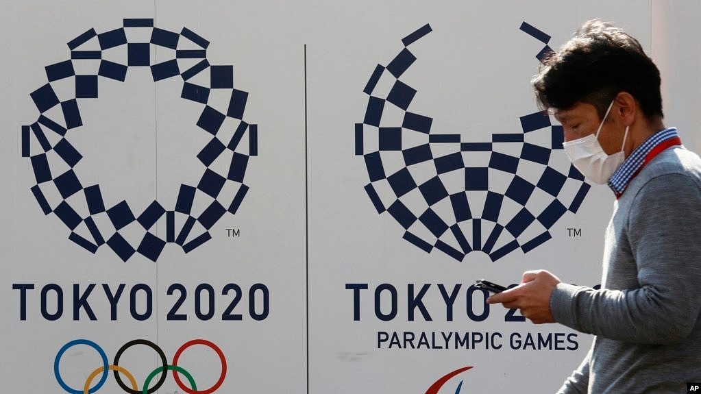 资料照片-东京一名男子走过东京奥运会和残奥会的标志。(2021年2月1日)