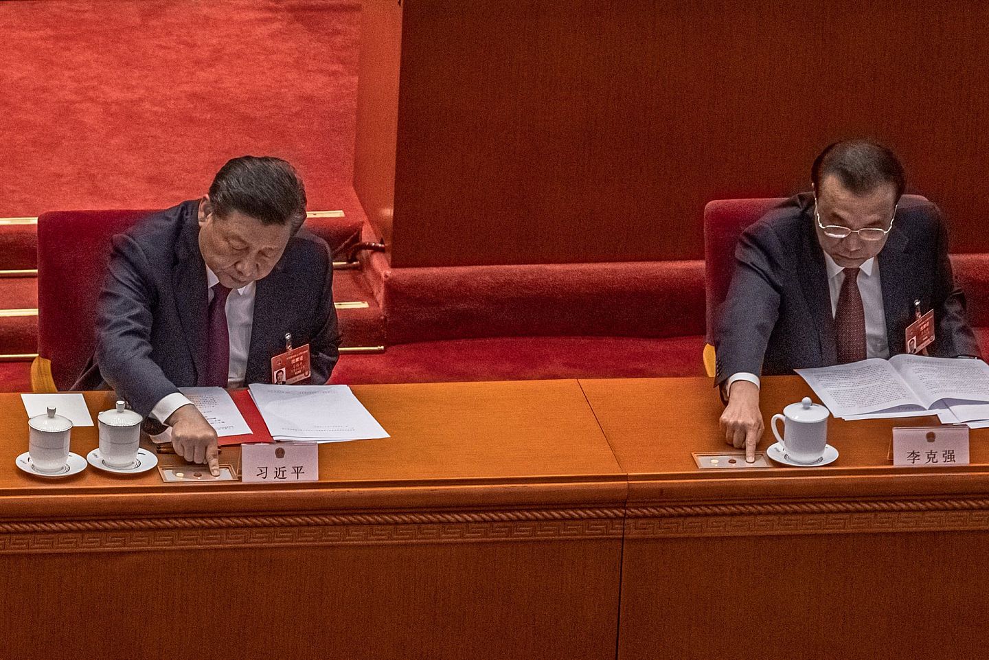 中国国家主席习近平(左)和国务院总理李克强于2021年3月11日，在北京人民大会堂举行的全国人民代表大会闭幕会议上按下按钮，就香港选举规则草案进行投票。 (AP)