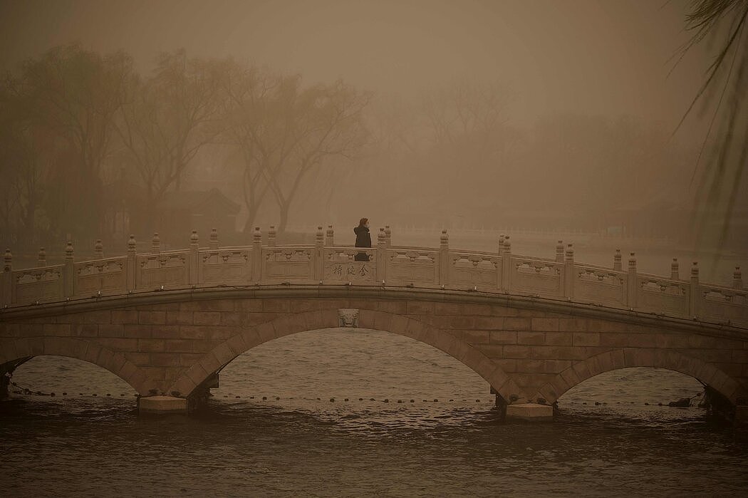 一名女子走在北京后海的一座桥上。