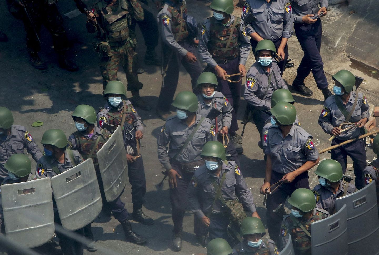 2021年3月3日，在缅甸曼德勒，警察和士兵手持枪支和弹弓走向反政变抗议者。（AP）