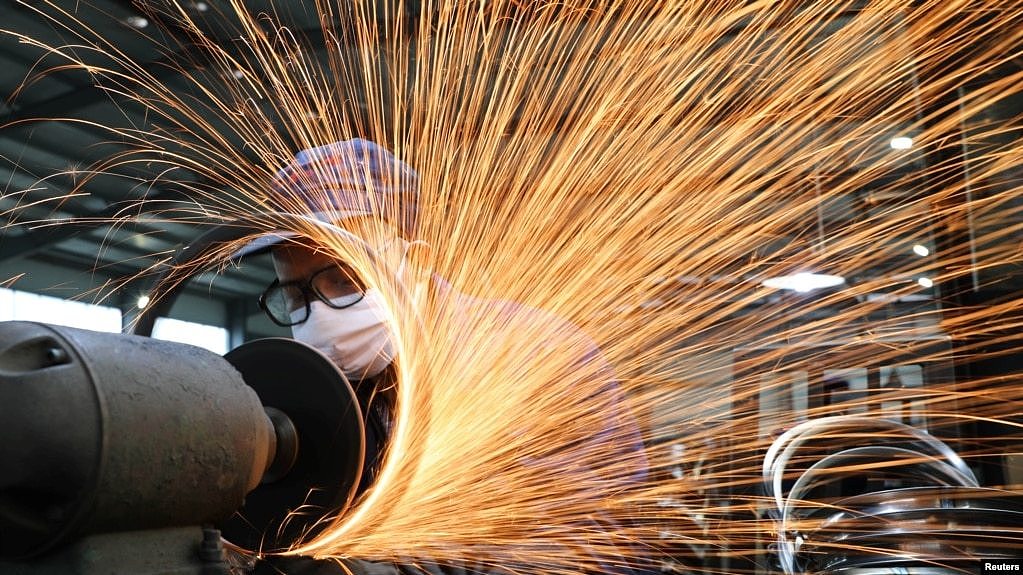 浙江杭州市一名戴着口罩的工人在生产自行车轮子钢圈的生产线上工作。（2020年3月2日）
