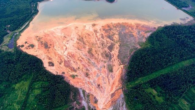 俄罗斯乌拉尔山区一处废弃的硫化铜矿，橙色的河水向矿区周围的森林扩散