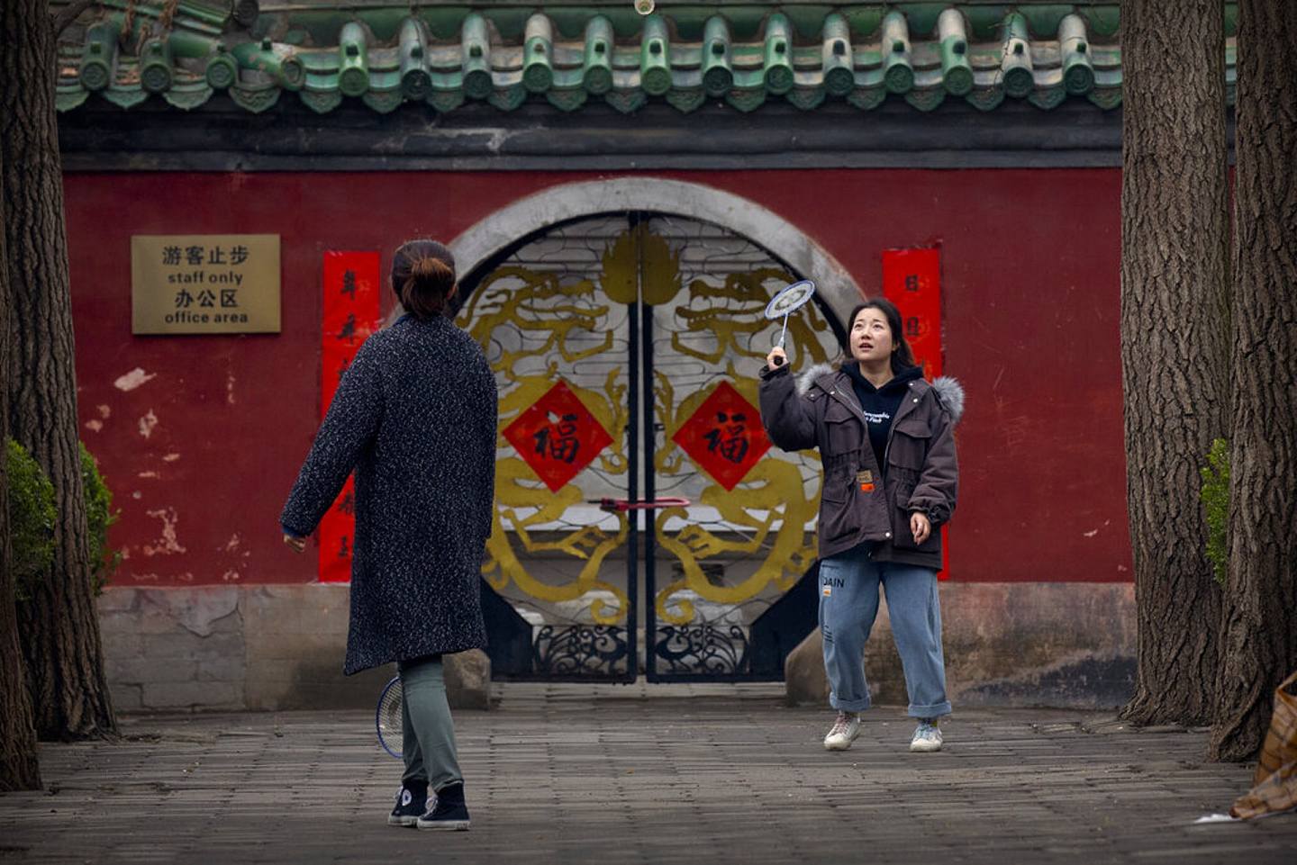 中国新冠肺炎疫情：图为3月18日中国北京2名女子在公园打羽毛球。 （AP）