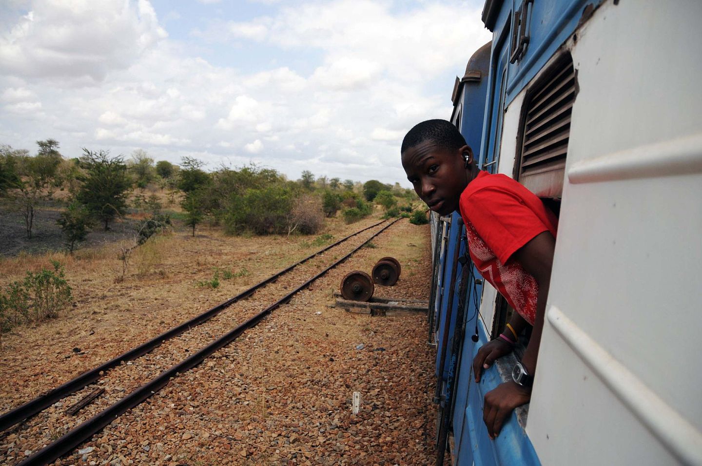 过去60多年来，非洲是中国援助的重点地区，从东非高原到西非海滨，从撒哈拉大沙漠的内陆国家到南部非洲的小岛国，中国援建的铁路、港口、会议中心、体育馆、图书馆等等，已成为非洲国家的亮丽风景。图为2011年9月17日，一名乘客在坦桑尼亚坦赞铁路的列车上观赏窗外风景。（新华社）