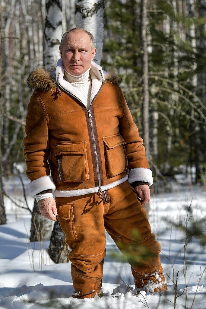 在另一张在西伯利亚拍摄的照片中，普京身穿豪华但舒适的羊皮夹克，搭配配套的裤子和象牙白高领衫，站在齐膝的雪地里。