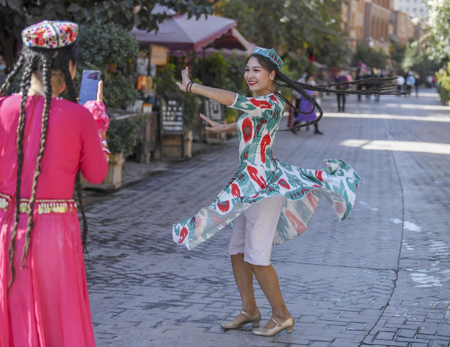 喀什古城吸引了越来越多的游客前来感受古城的烟火气。图为9月20日， 喀什古城居民在拍照留影。（新华社）