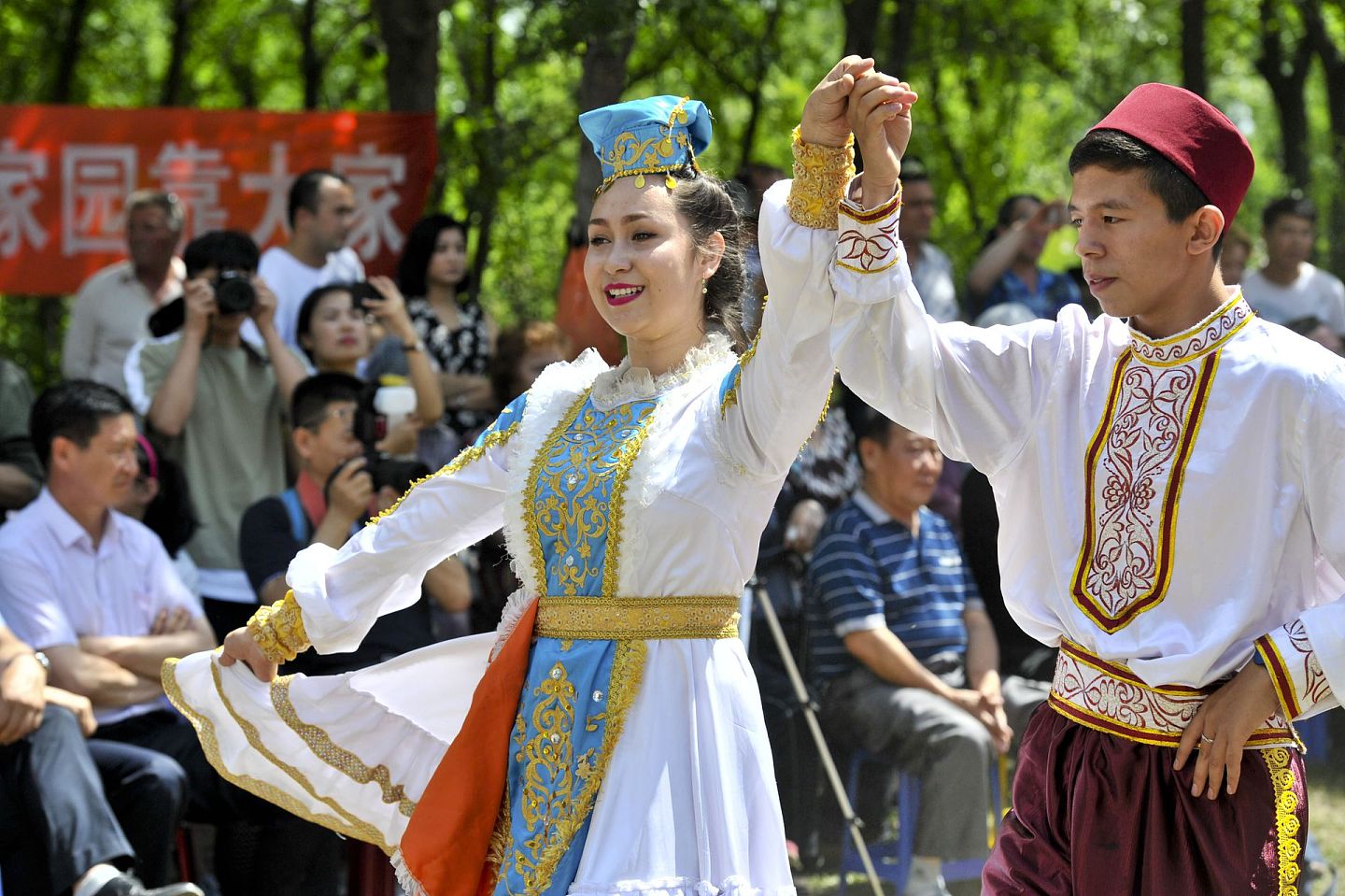 2017年7月22日，新疆塔城地区塔城市的居民在“撒班节”上跳舞。（新华社）