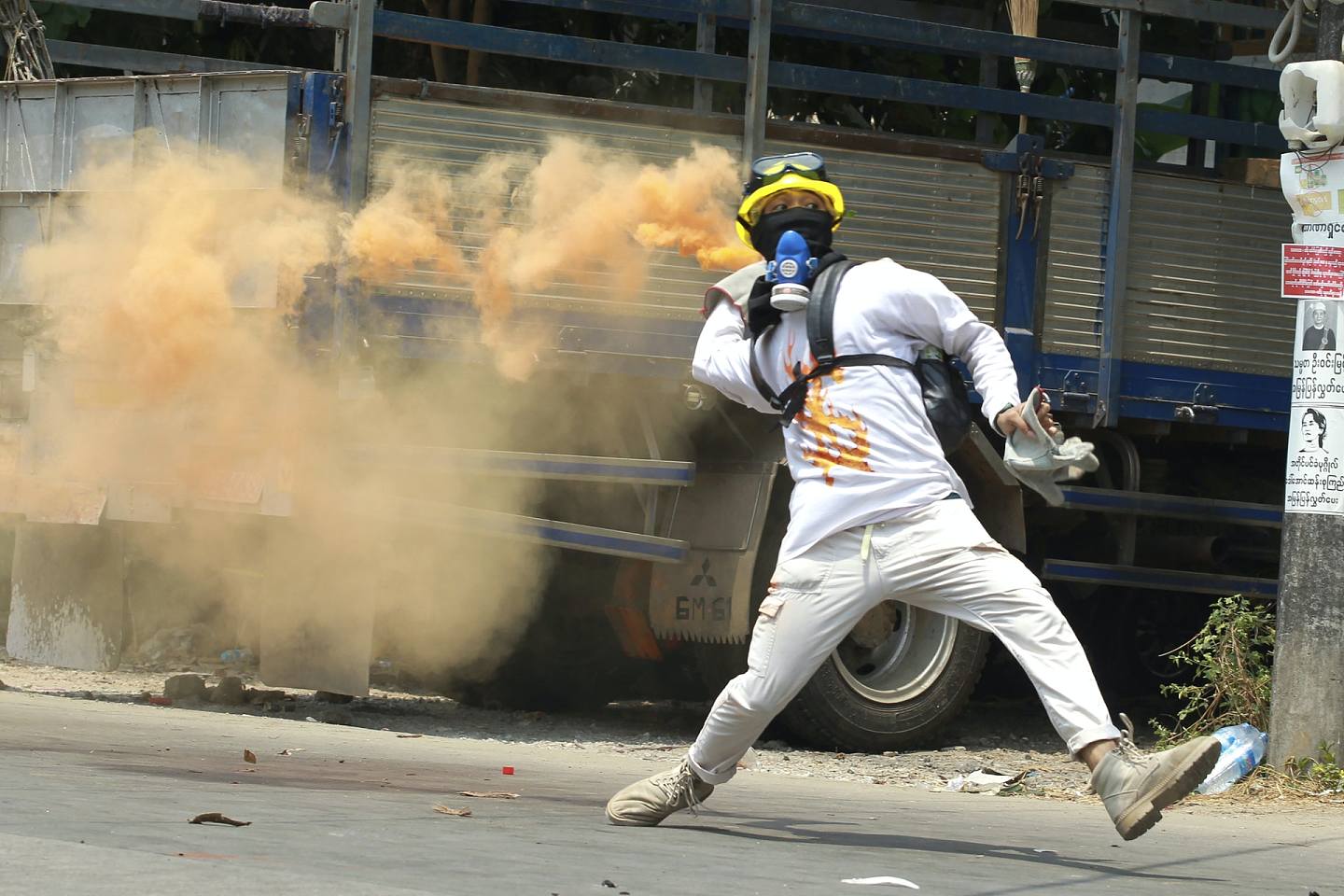 缅甸政变：图为3月27日一示威者在仰光手持一个烟雾弹。 （AP）