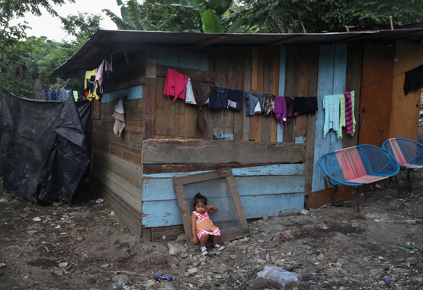 2017年8月，一名小孩坐在洪都拉斯一个穷困的街区外。该国常年位列西半球最穷苦的国家之列。（Getty）