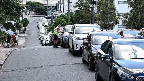 The cars of Brisbane residents as they wait to be tested for coronavirus.