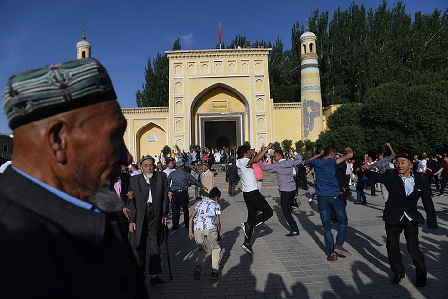 2019年6月5日，新疆喀什某大型清真寺广场前，维族穆斯林载歌载舞欢庆斋戒节的结束。（Getty Images）
