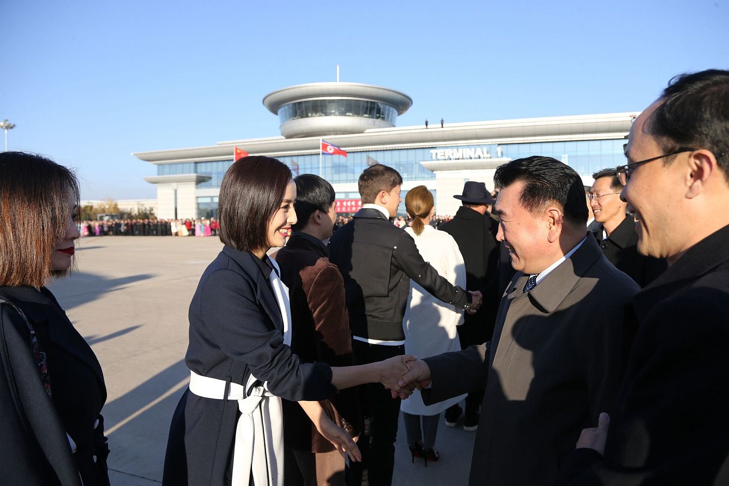 2018年11月2日 ，中国文艺工作者代表团成员在机场与朝鲜官员握手互动。（新华社）