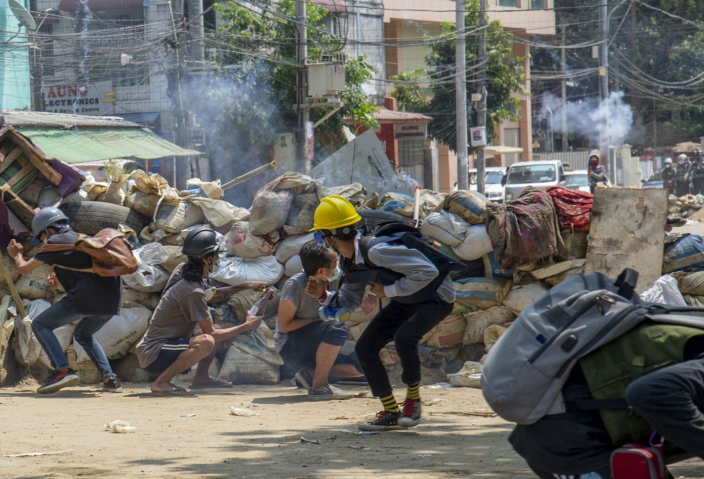 2021年3月16日，在缅甸仰光，武装防暴警察发射催泪瓦斯和橡皮子弹后，反政变抗议者放弃他们的临时路障逃跑。（AP）