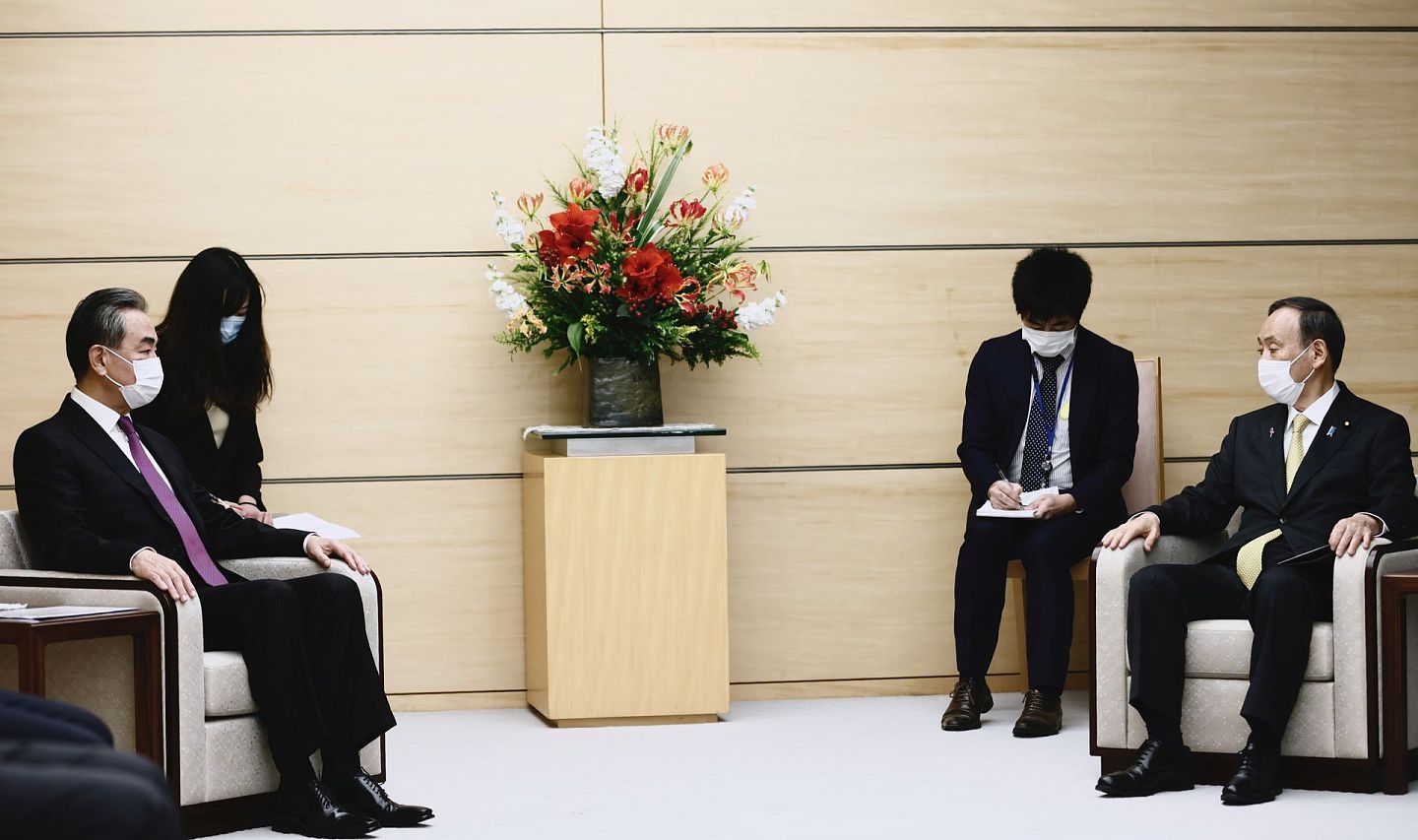 日本首相菅义伟在首相官邸会晤了王毅，这是两人首次会晤。因为疫情问题，两人在交谈时明显保持了社交距离。（Reuters）