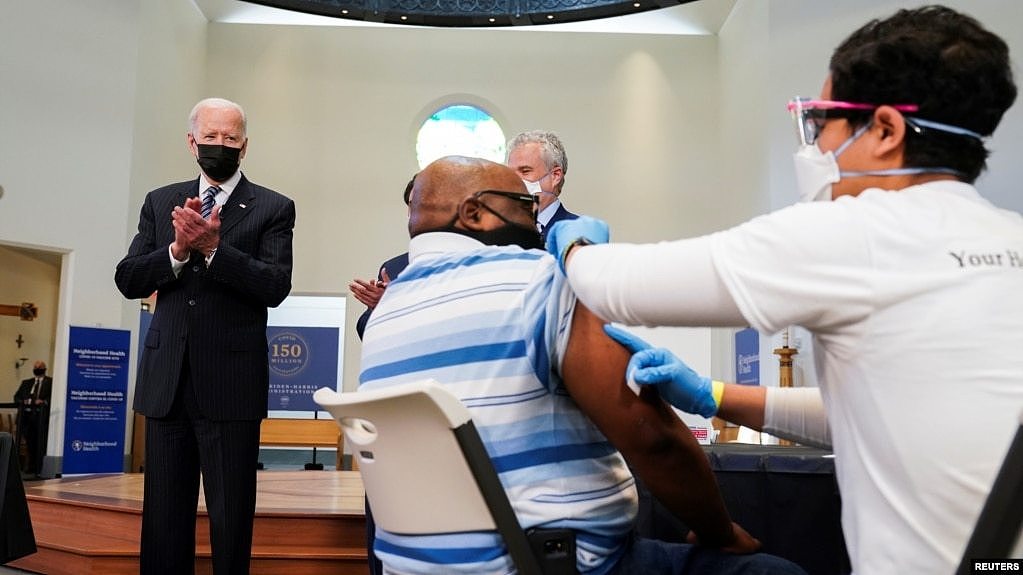 美国总统拜登在弗吉尼亚神学院设立的新冠疫苗接种站为接种疫苗的民众鼓掌。(2021年4月6日)