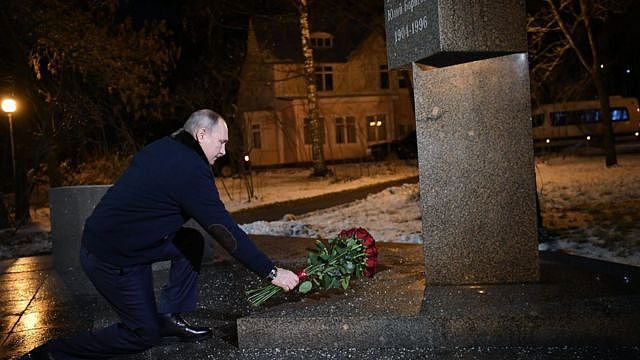 President Putin laying flowers on a grave
