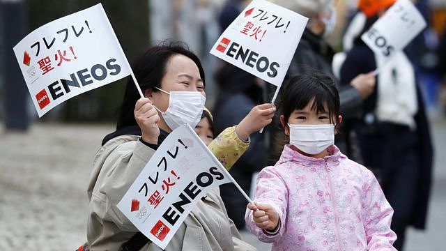 Spectators wearing face masks wait for the arrival of the Tokyo 2020 Olympic torch relay, amid the coronavirus disease (COVID-19) pandemic, on the second day of the relay in Fukushima, Japan March 26, 2021.