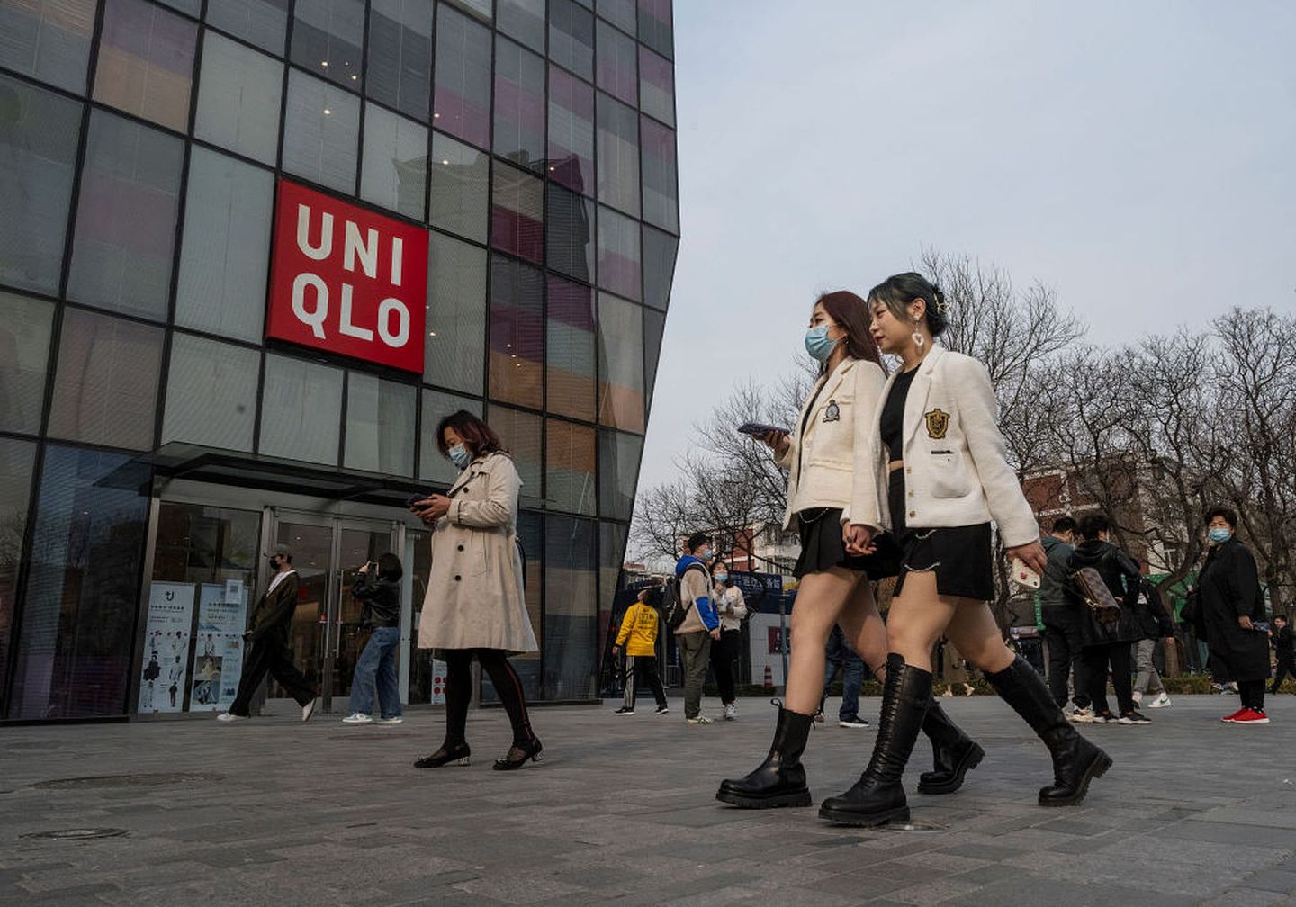 图为3月25日，北京民众在一幢建筑物旁走过，建筑物上有UNIQLO标志。（Getty）