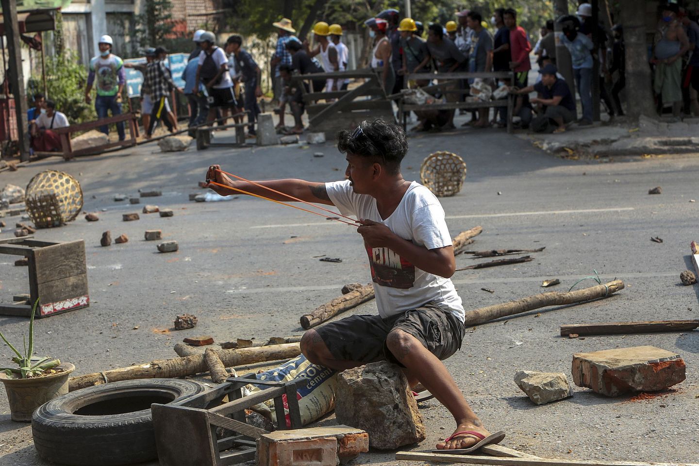2021年3月2日，在缅甸曼德勒，一名示威者使用弹弓对抗警察。（AP）