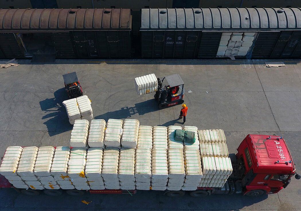 上个月，中国中部江西省九江，一个铁路货运站正在搬运新疆地区生产的棉花。