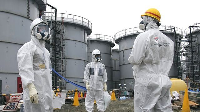 东京电力公司人员身穿防护衣带领记者视察福岛第一核电站残骸（7/11/2013）