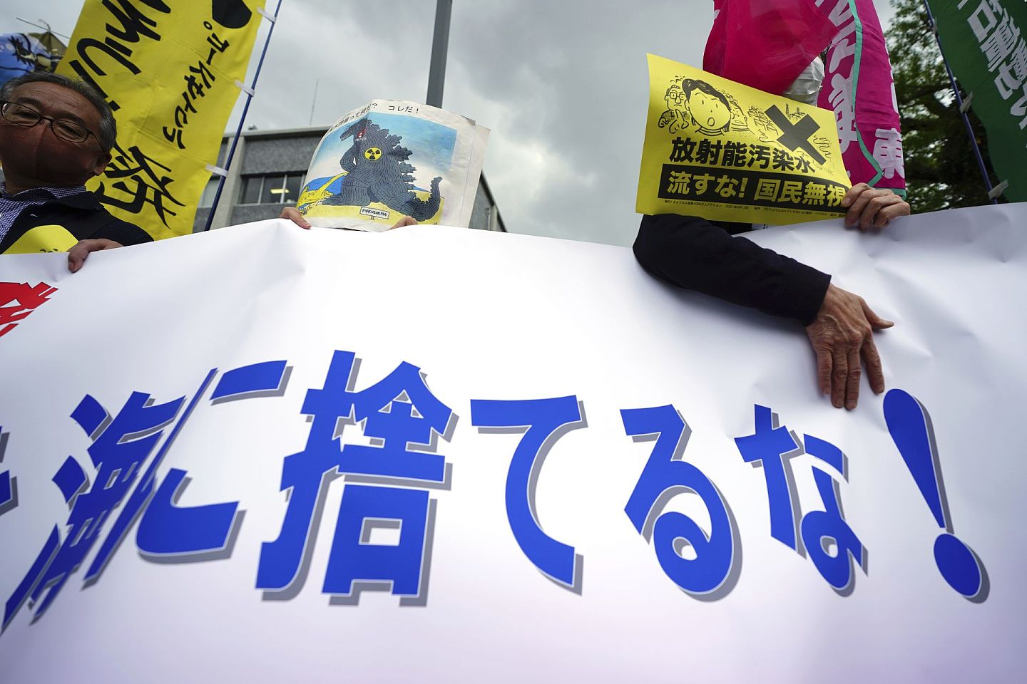2021年4月13日，一位抗议者在东京首相办公室外的一次集会上散布传单，上面写着“不要将放射性水倒入大海”。（AP）