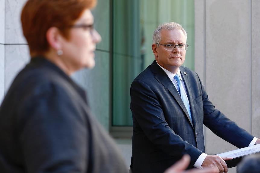 Morrison looks on as Payne speaks