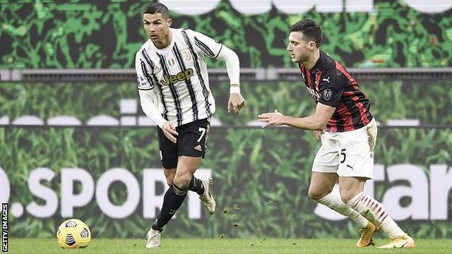 Juventus forward Cristiano Ronaldo (left) dribbles past AC Milan player Diogo Dalot (right)