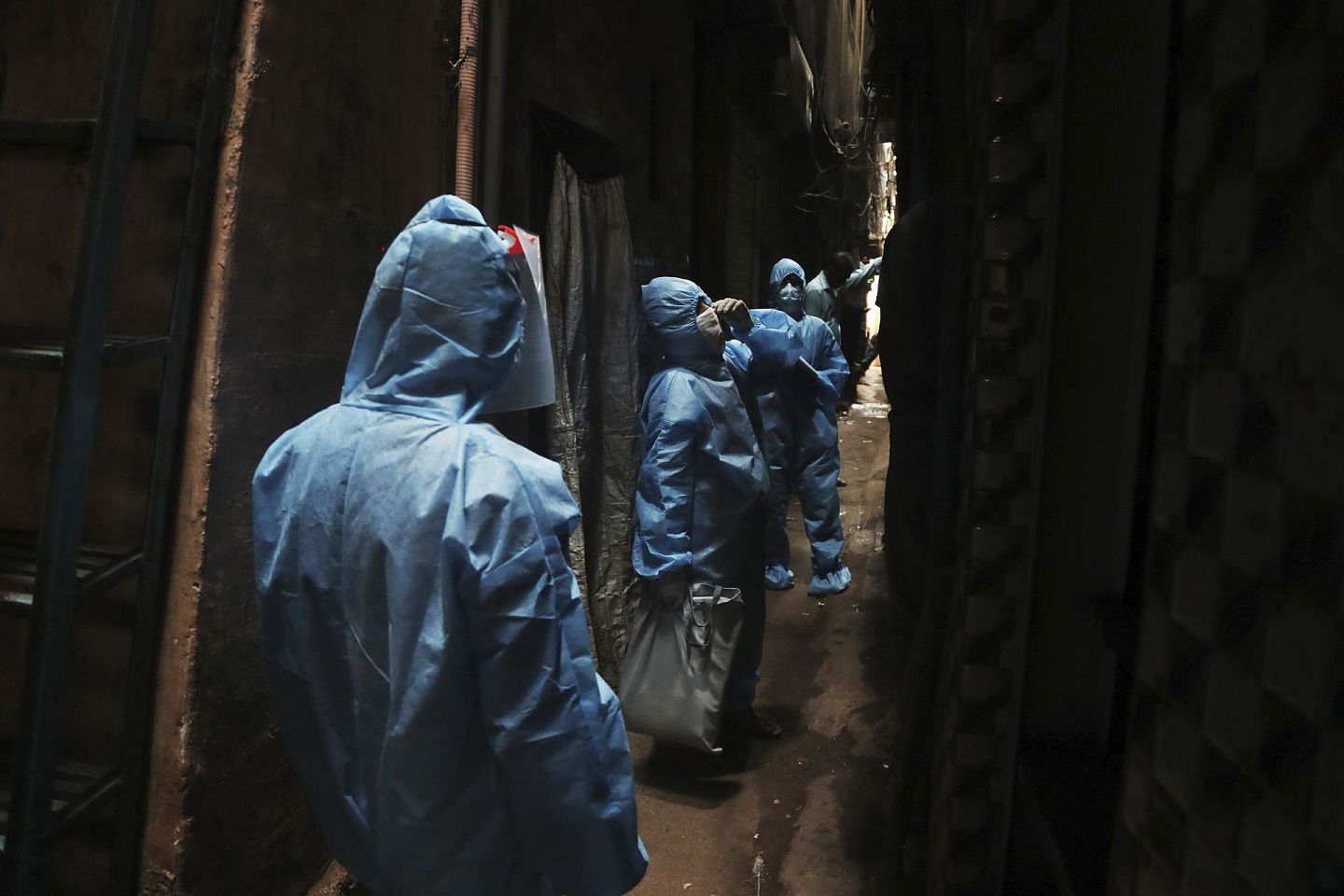 2020年4月1日，身穿防护服的工作人员在孟买达拉维贫民窟中巡查，以防止新冠肺炎疫情传播。（AP）