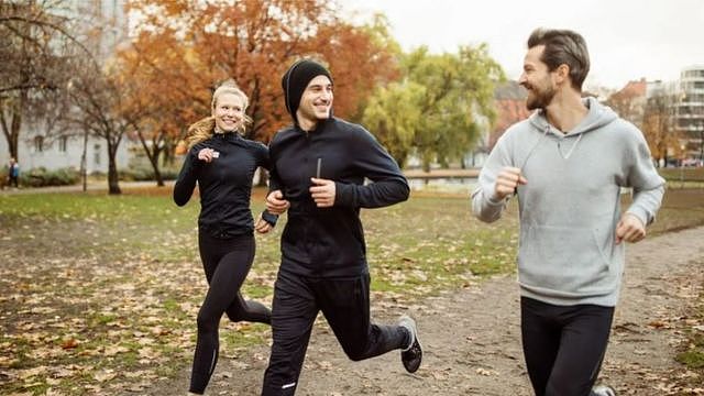 Three people running in a park