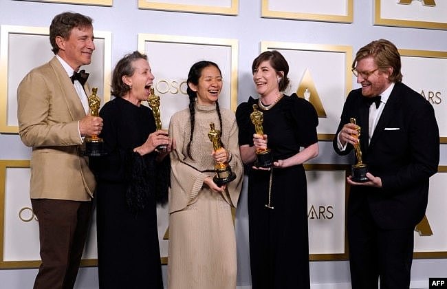 2021年4月25日获得奥斯卡最佳导演奖的赵婷(中)与其最佳影片《无依之地》的其他获奖人员在一起。