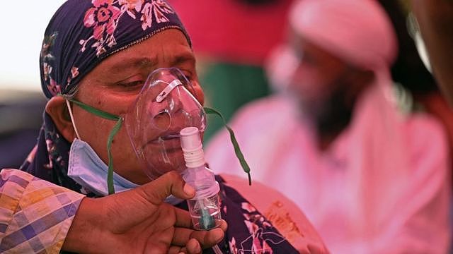 Patients breathe with the help of oxygen provided by a Gurdwara, a place of worship for Sikhs, under a tent installed along the roadside amid Covid-19 coronavirus pandemic in Ghaziabad on April 26, 2021.